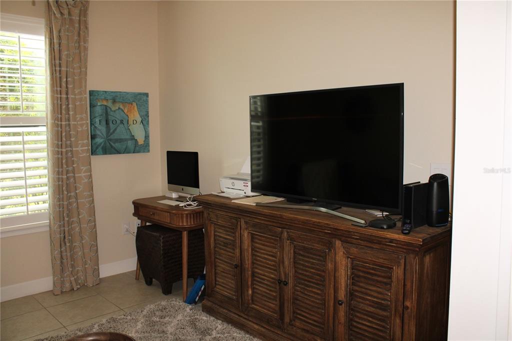 13711 Messina Loop, Unit 104 Bradenton, FL 34211 - Photo 29 of 70 a room that has a flat screen tv and a table in it