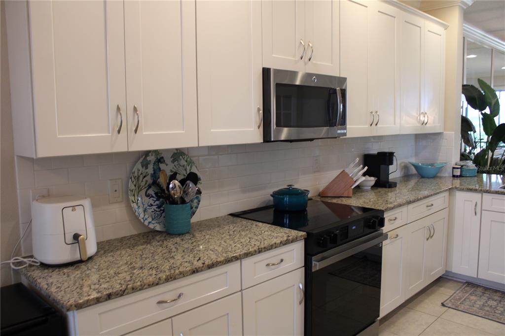 13711 Messina Loop, Unit 104 Bradenton, FL 34211 - Photo 3 of 70 a kitchen with stainless steel appliances granite countertop white cabinets sink and stove
