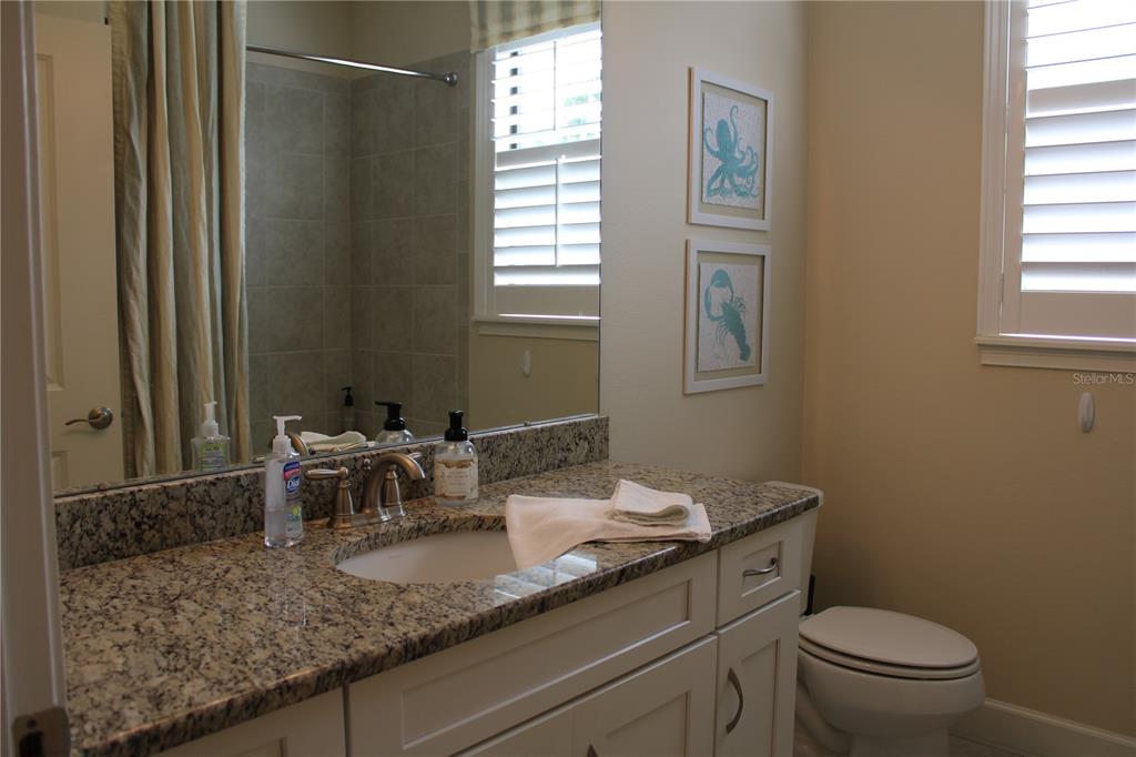 13711 Messina Loop, Unit 104 Bradenton, FL 34211 - Photo 32 of 70 a bathroom with a granite countertop sink toilet and mirror