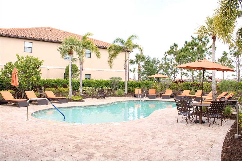 13711 Messina Loop, Unit 104 Bradenton, FL 34211 - Photo 48 of 70 a view of a swimming pool with chairs in patio