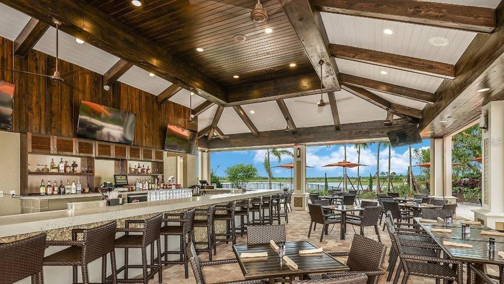 13711 Messina Loop, Unit 104 Bradenton, FL 34211 - Photo 63 of 70 a room with lots of wooden furniture and large windows