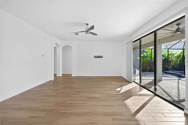 a view of a hallway with wooden floor and windows
