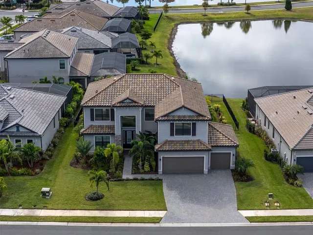 an aerial view of a house with swimming pool and outdoor seating