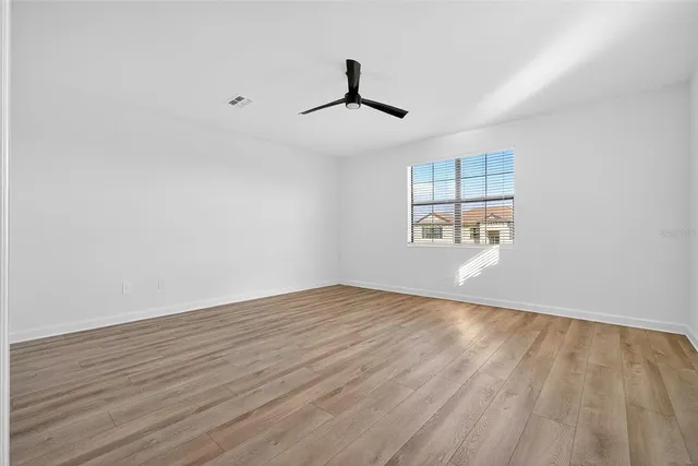 front view of a house with a yard and palm trees