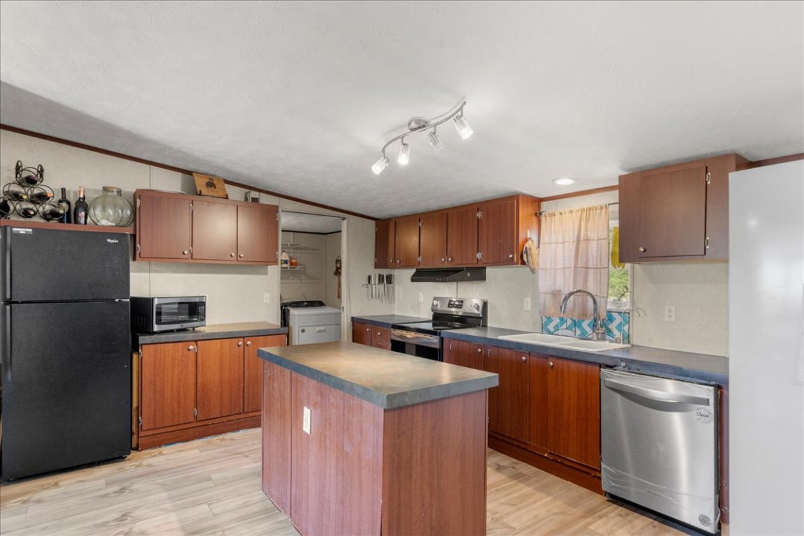 1307 Graef Road, Unit B Kyle, TX 78640 - Photo 18 of 40 a kitchen with stainless steel appliances granite countertop a sink stove refrigerator and cabinets