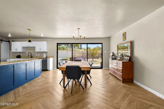 a open kitchen with stainless steel appliances granite countertop a stove a refrigerator a sink dishwasher with a dining table and chairs with wooden floor