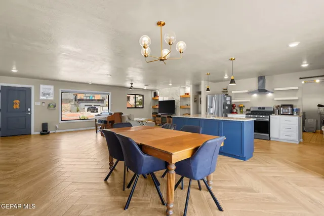 a kitchen with stainless steel appliances kitchen island granite countertop a table chairs sink and cabinets