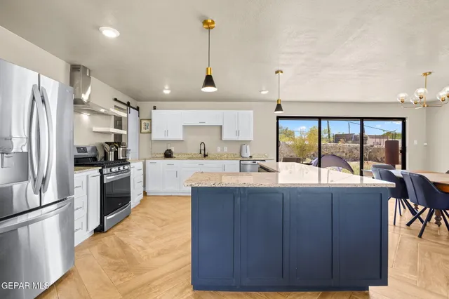 an open kitchen with granite countertop kitchen island wooden cabinets and stainless steel appliances
