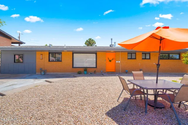 a backyard of a house with table and chairs