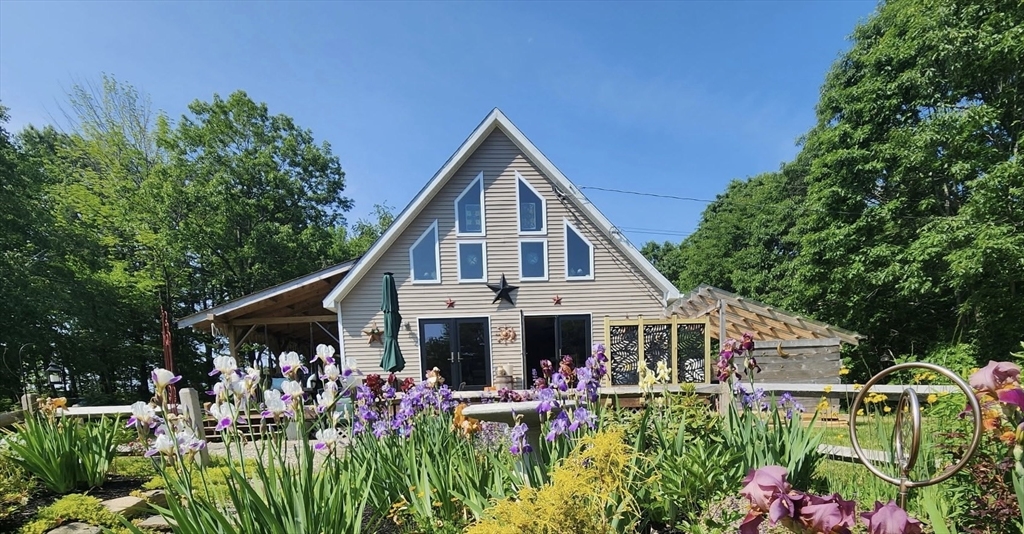 a view of a house with a big yard and potted plants