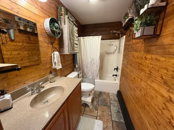 a bathroom with a granite countertop sink toilet and shower