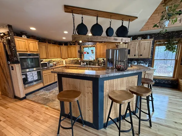 a kitchen with stainless steel appliances granite countertop table chairs sink and cabinets