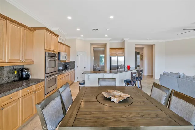 a large kitchen with stainless steel appliances granite countertop a stove a sink a dining table and chairs