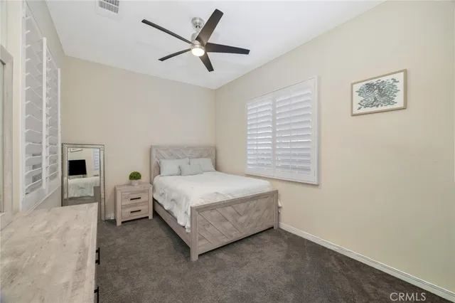 a spacious bedroom with a bed and a ceiling fan
