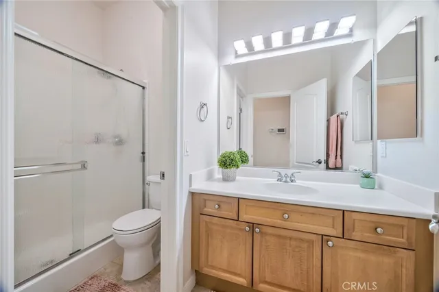 a bathroom with a granite countertop sink a toilet and a large mirror