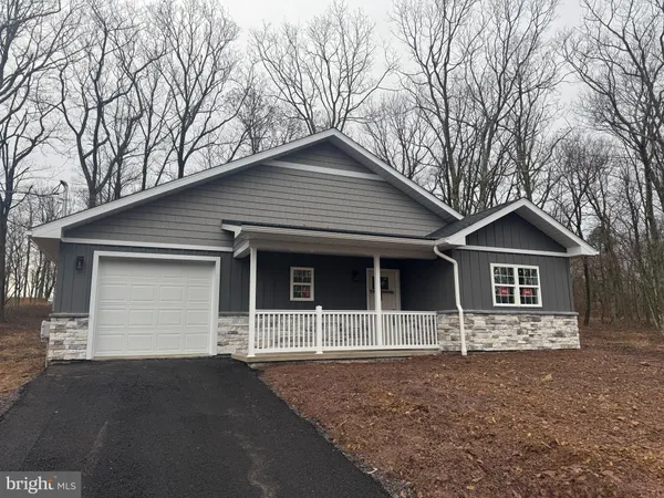 a front view of a house with yard and trees