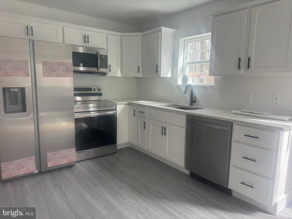 a kitchen with kitchen island a sink stainless steel appliances and cabinets