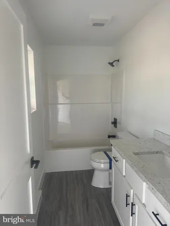 a bathroom with a granite countertop toilet a sink and a shower