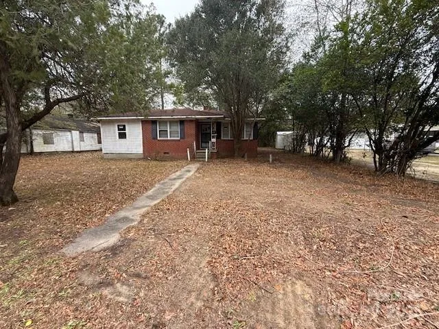 a view of a house with a tree in front of it