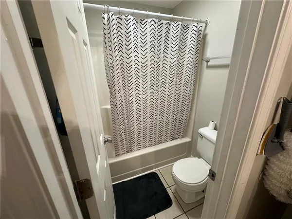 a bathroom with a toilet and a shower curtain