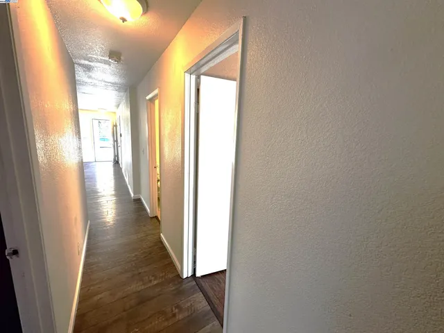a view of a hallway with wooden floor and stairs