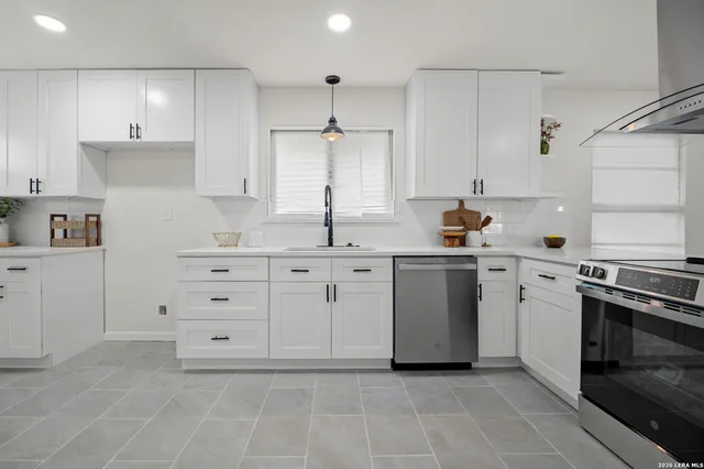 a kitchen with white cabinets and stainless steel appliances