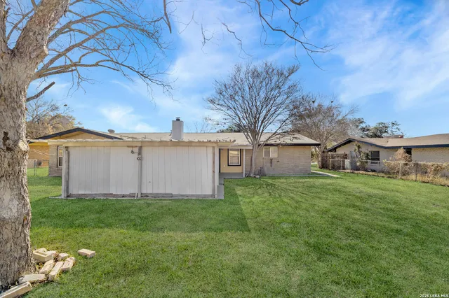 a white house that has a tree in front of it