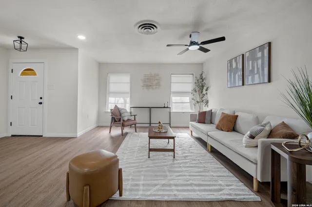 a living room with furniture and a wooden floor