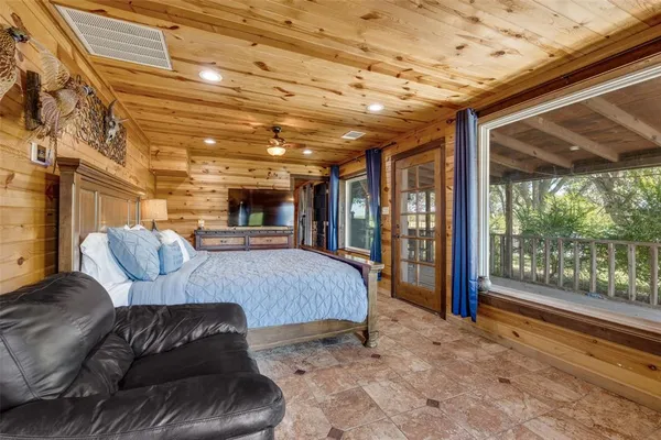 a spacious bedroom with a bed and glass door