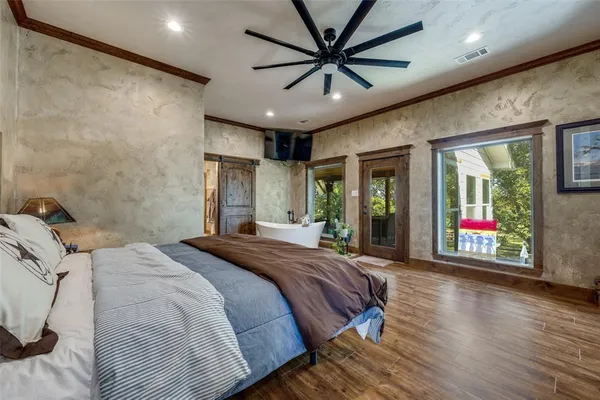 a spacious bedroom with a bed and a chandelier