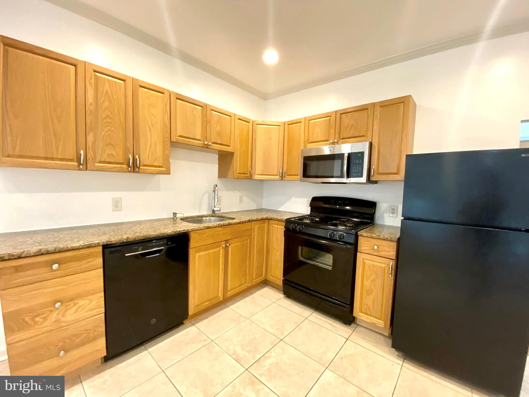3856 Terrace Street Philadelphia, PA 19128 - Photo 14 of 27 a kitchen with granite countertop a refrigerator stove top oven and sink