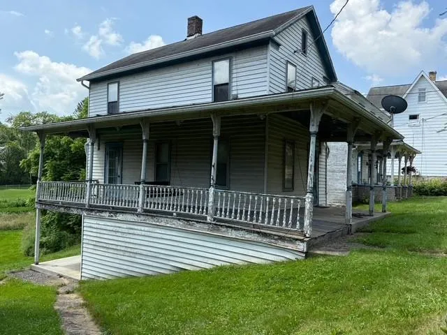 a view of a house with a yard and potted plants