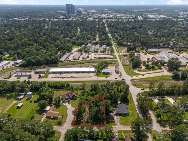 an aerial view of residential houses with outdoor space and trees