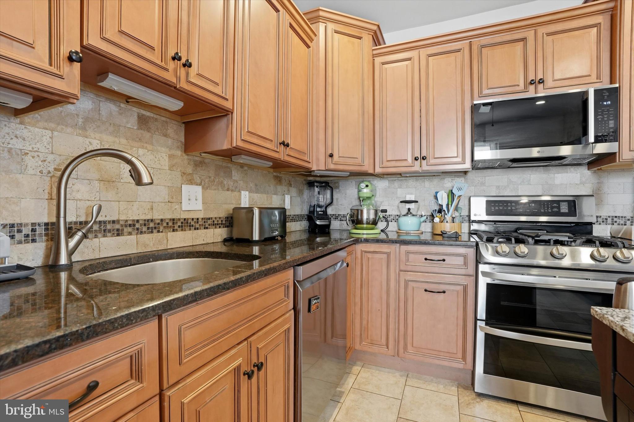 425 Righter Street Philadelphia, PA 19128 - Photo 12 of 35 a kitchen with stainless steel appliances granite countertop a sink and a stove