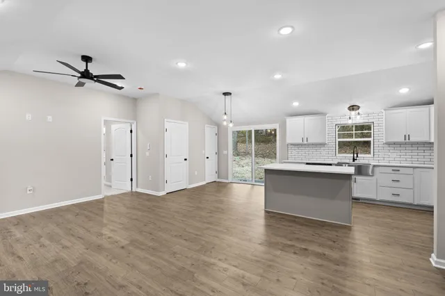 a view of kitchen with stainless steel appliances refrigerator oven stove and white cabinets