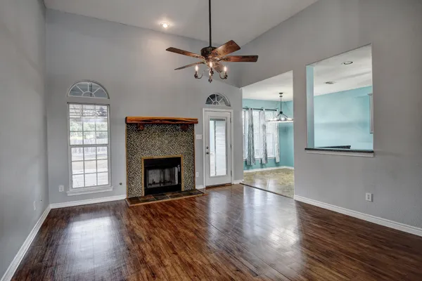 a view of a livingroom with a fireplace window and wooden floor