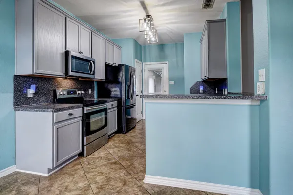 a kitchen with stainless steel appliances granite countertop a refrigerator a stove top oven a sink and dishwasher