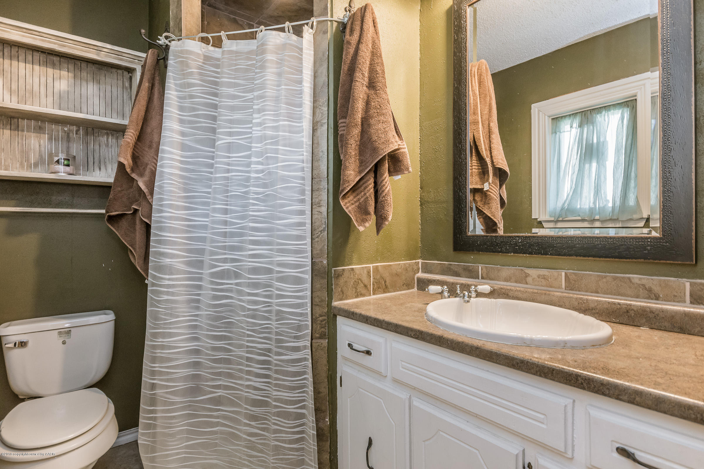 5332 Whitney Lane Amarillo, TX 79110 - Photo 12 of 17 a bathroom with a granite countertop toilet sink and mirror