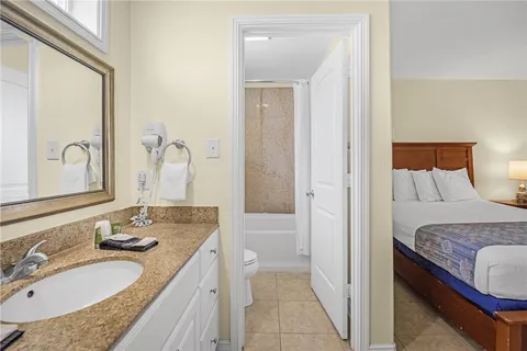 a en suite bathroom with a granite countertop sink and a mirror