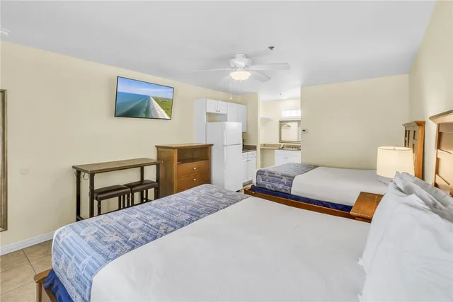 a bedroom with a bed a dresser and potted plant on the dresser