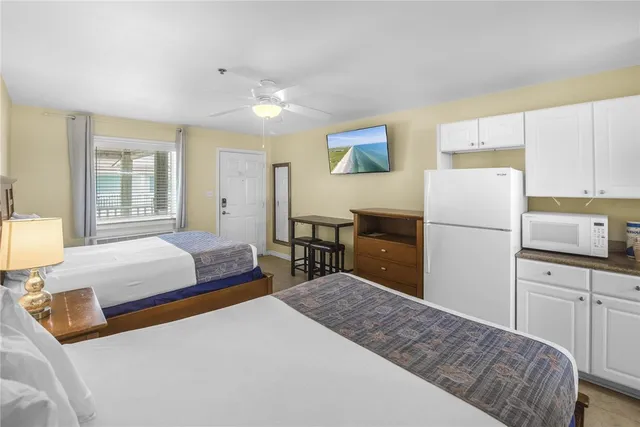 a bedroom with a bed and a refrigerator
