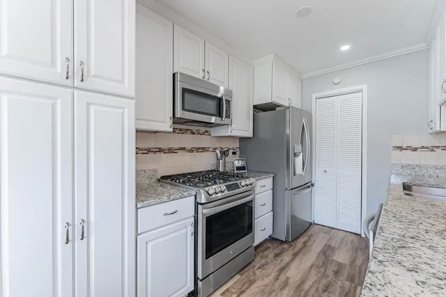 a kitchen with stainless steel appliances granite countertop a stove a refrigerator and a microwave