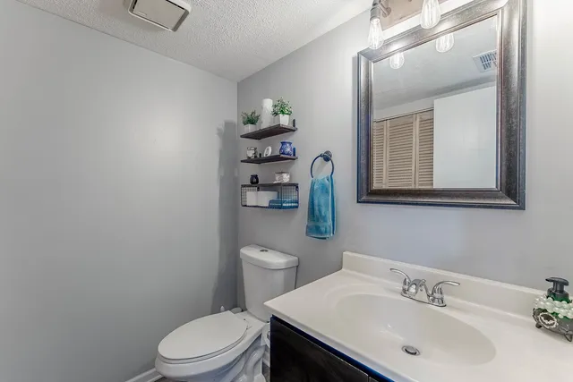 a bathroom with a sink a toilet and mirror