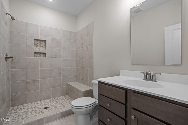 a bathroom with a sink toilet a mirror and shower