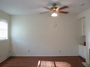 a view of a room with a window and wooden floor