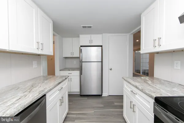a kitchen with granite countertop a refrigerator and a sink