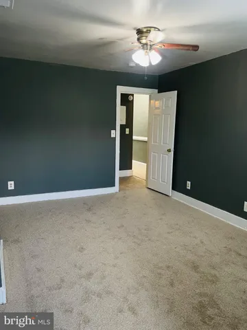 en empty room with windows and fan