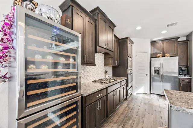 a kitchen with stainless steel appliances granite countertop a refrigerator and a stove top oven
