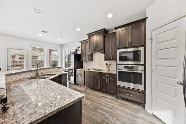 a open kitchen with stainless steel appliances granite countertop a stove a sink and a refrigerator