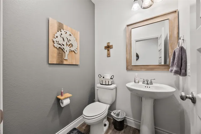 a bathroom with a toilet sink and mirror